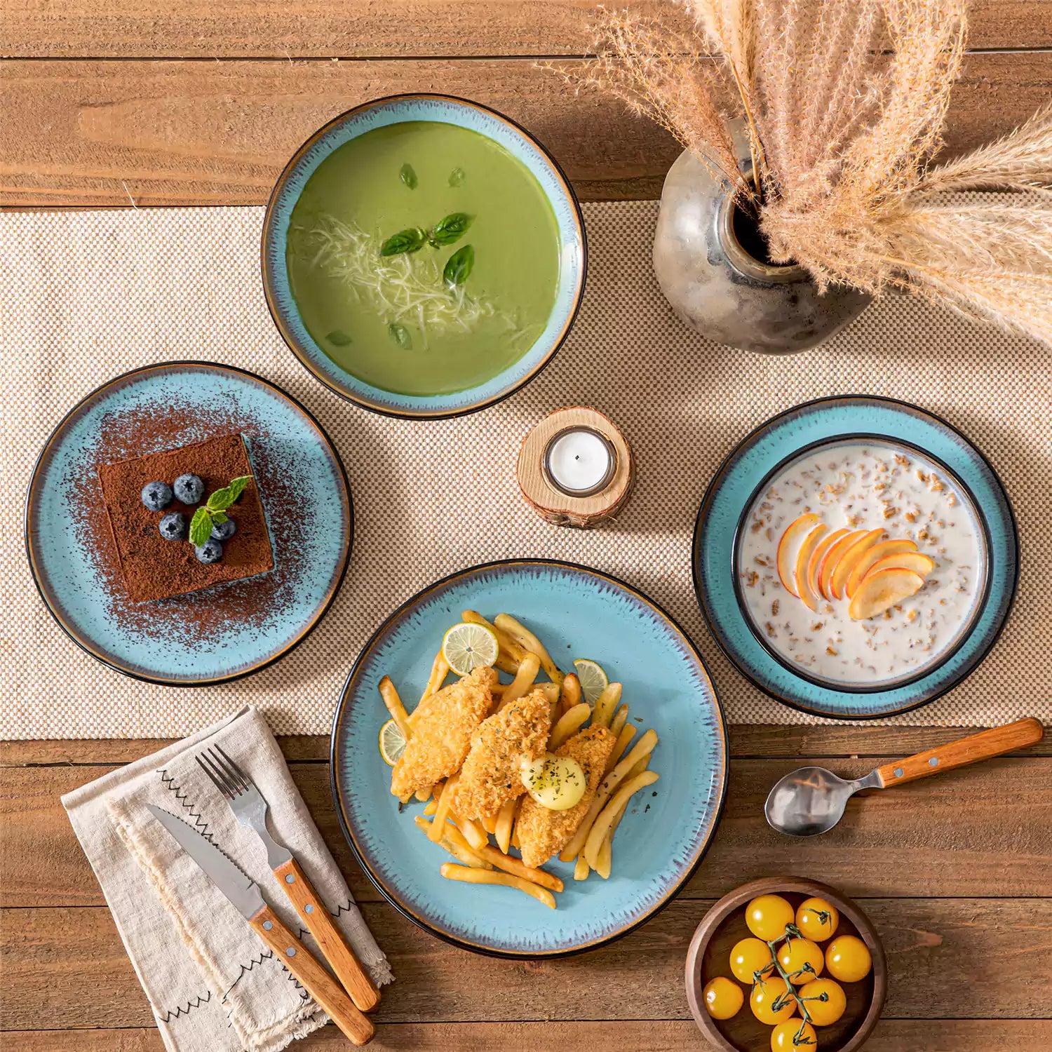 Assorted dishes with soup - dessert - and fruit salad on rustic wooden table - Amber 16-Piece blue stoneware dinnerware set with plates and bowls by vancasso