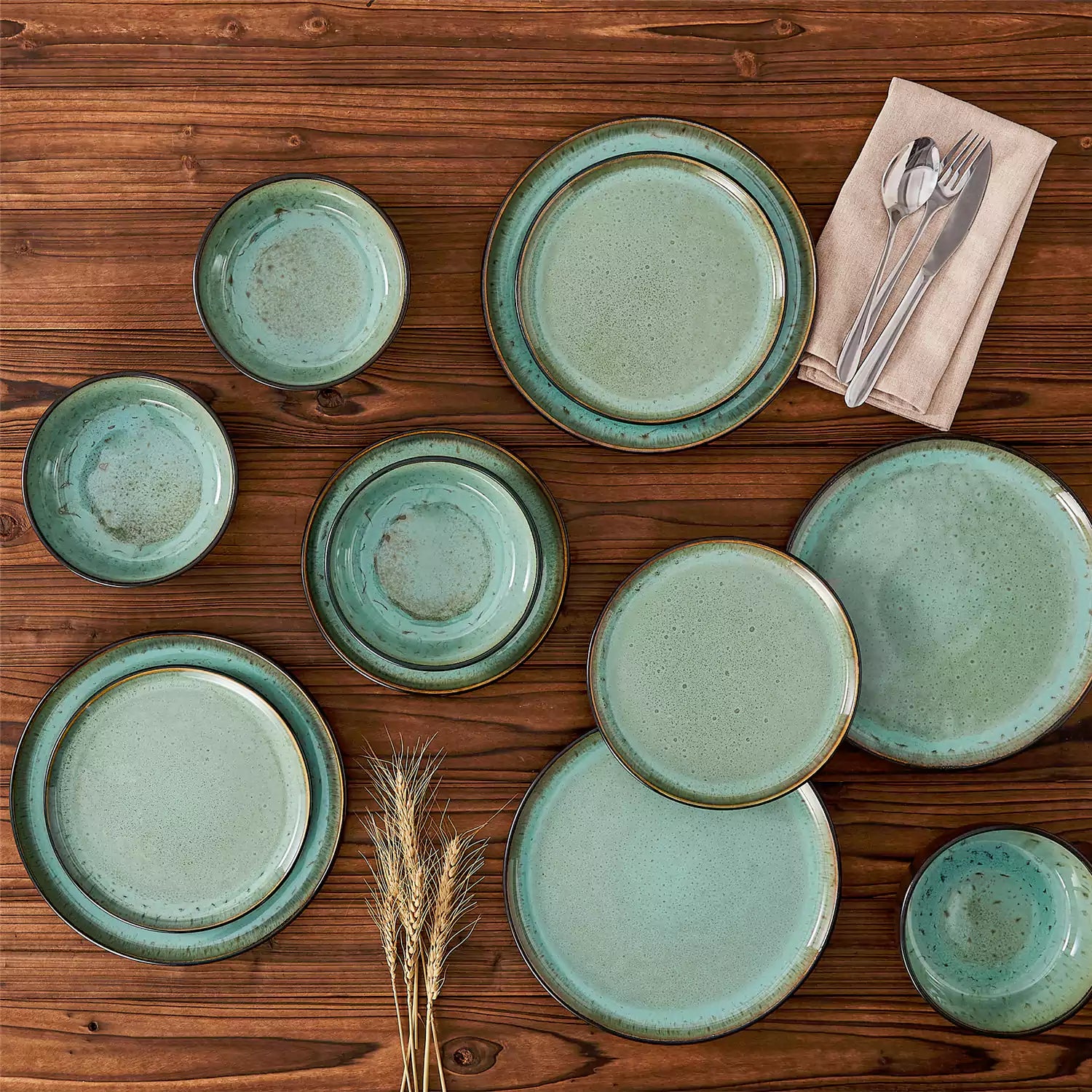 Rustic dining table with Amber 12-piece stoneware dinnerware in farmhouse green - featuring reactive glaze plates - bowls - and utensils by vancasso