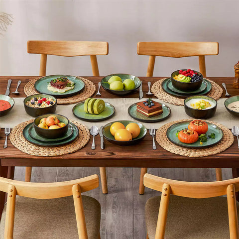 Assorted dishes with soup - dessert - and fruit salad on rustic wooden table - Amber 16-Piece green stoneware dinnerware set with plates and bowls by vancasso