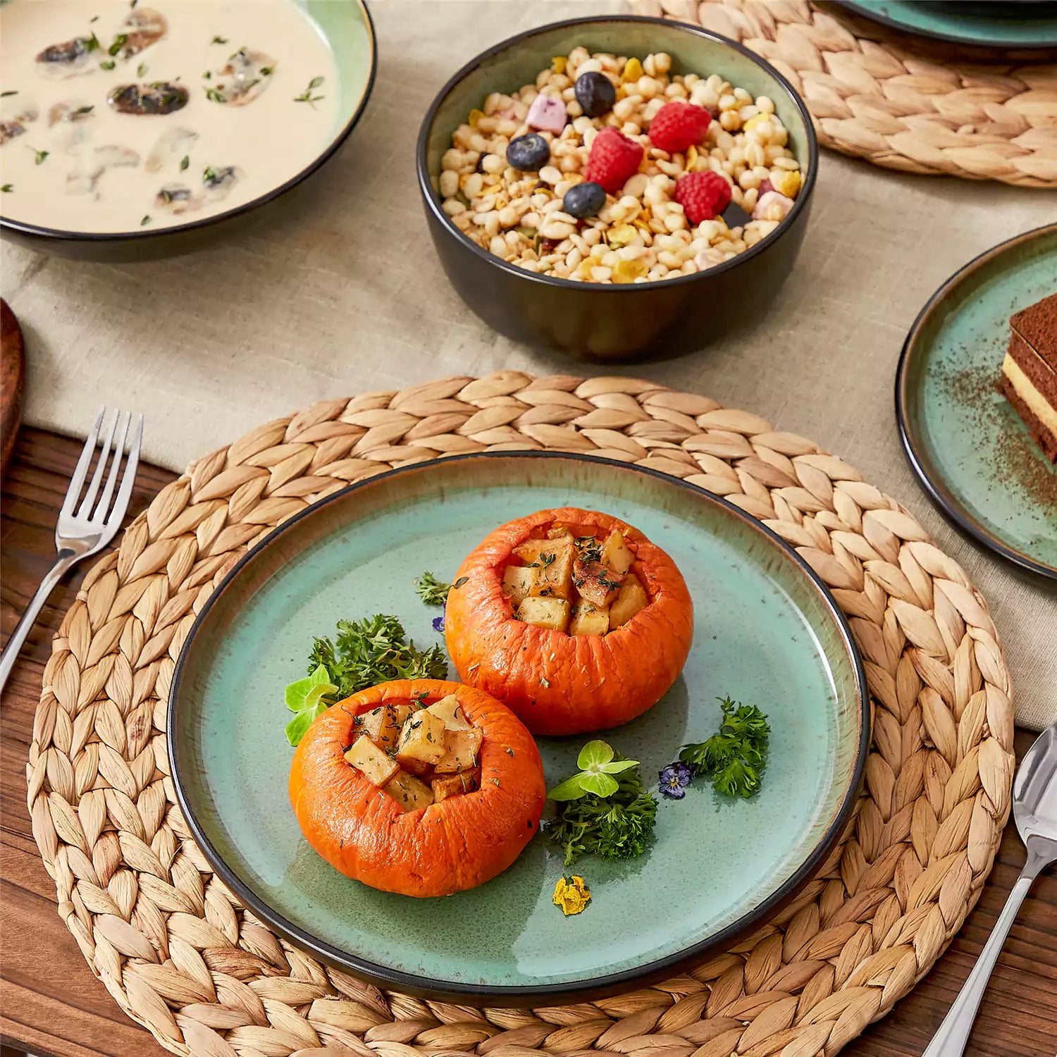Assorted dishes with soup - dessert - and fruit salad on rustic wooden table - Amber 16-Piece green stoneware dinnerware set with plates and bowls by vancasso