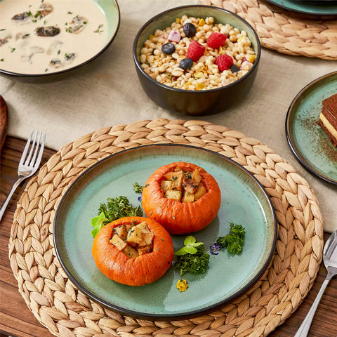 Assorted dishes with soup - dessert - and fruit salad on rustic wooden table - Amber 16-Piece green stoneware dinnerware set with plates and bowls by vancasso