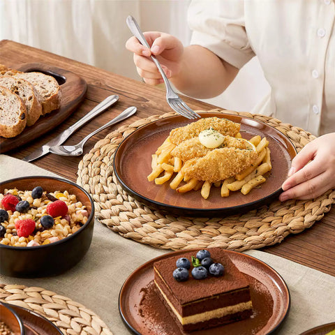 Rustic dining table with Amber 12-piece stoneware dinnerware in farmhouse red - featuring reactive glaze plates - bowls - and utensils by vancasso