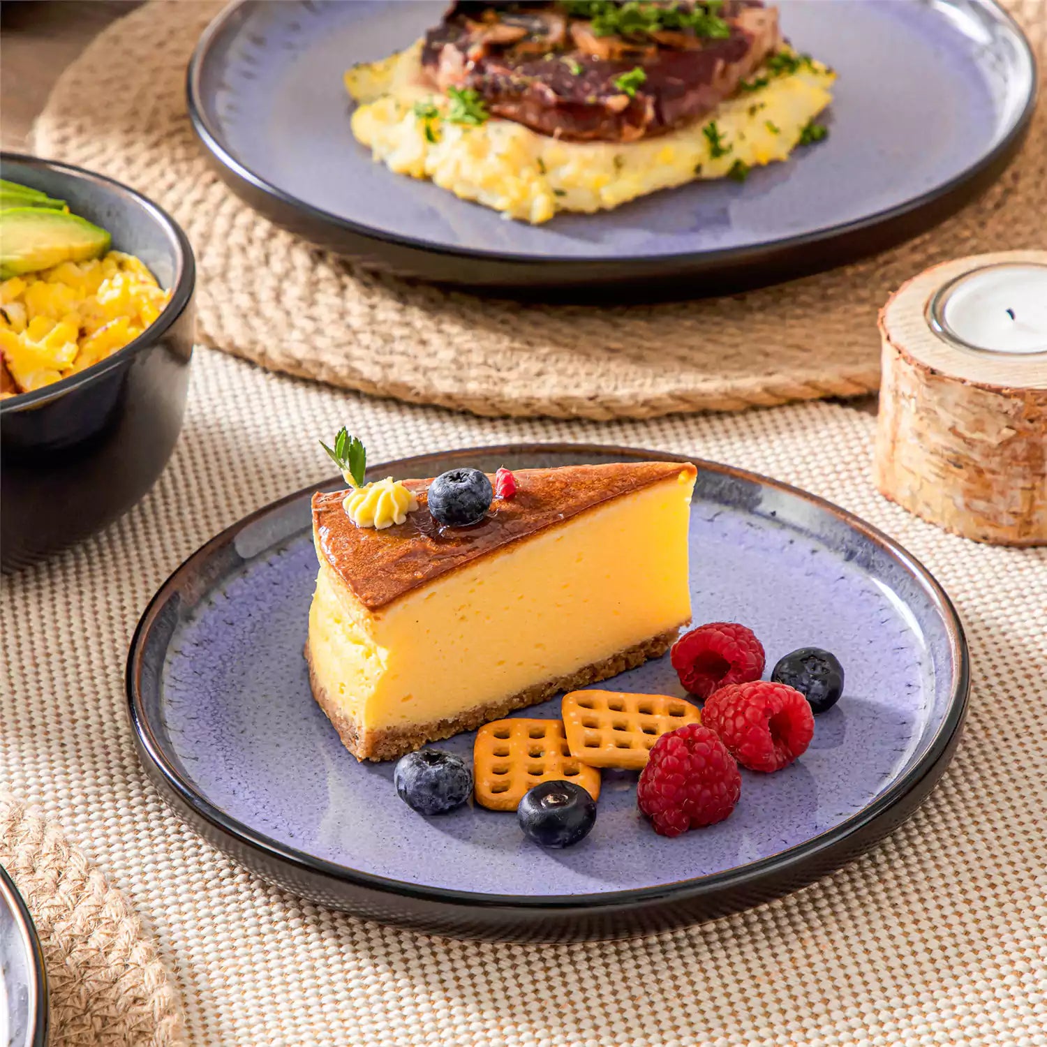 Rustic dining table with Amber 12-piece stoneware dinnerware in farmhouse violet - featuring reactive glaze plates - bowls - and utensils by vancasso