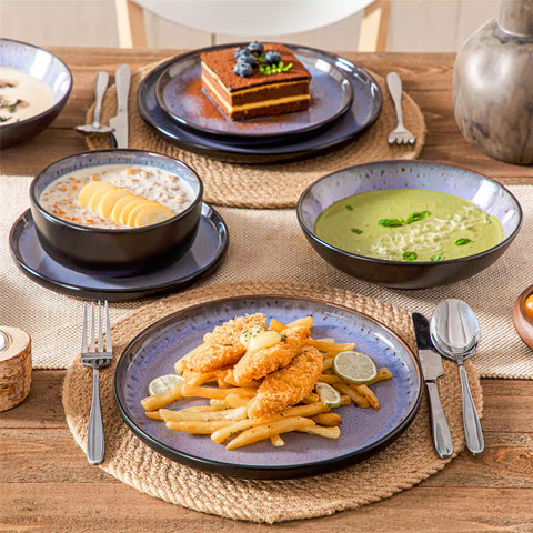 Assorted dishes with soup - dessert - and fruit salad on rustic wooden table - Amber 16-Piece violet stoneware dinnerware set with plates and bowls by vancasso