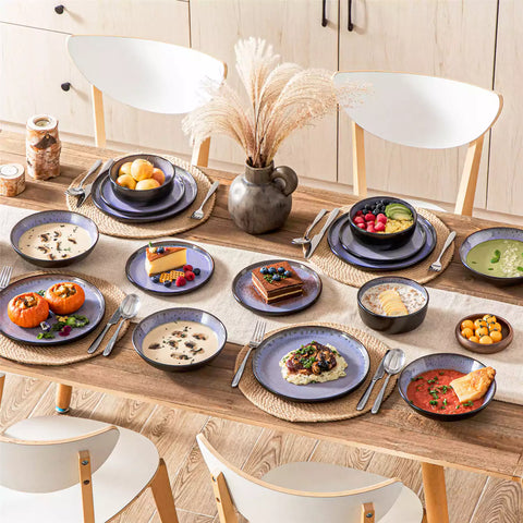Assorted dishes with soup - dessert - and fruit salad on rustic wooden table - Amber 16-Piece violet stoneware dinnerware set with plates and bowls by vancasso
