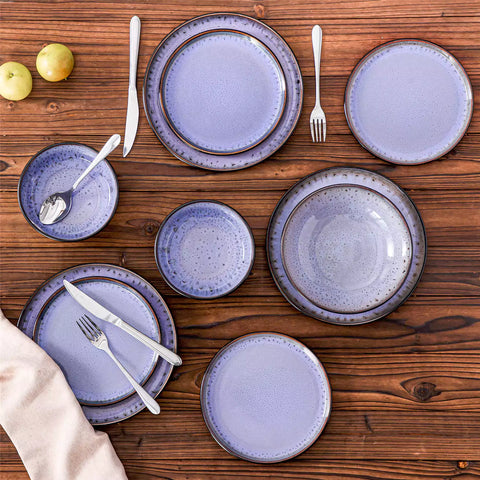 Assorted dishes with soup - dessert - and fruit salad on rustic wooden table - Amber 16-Piece violet stoneware dinnerware set with plates and bowls by vancasso