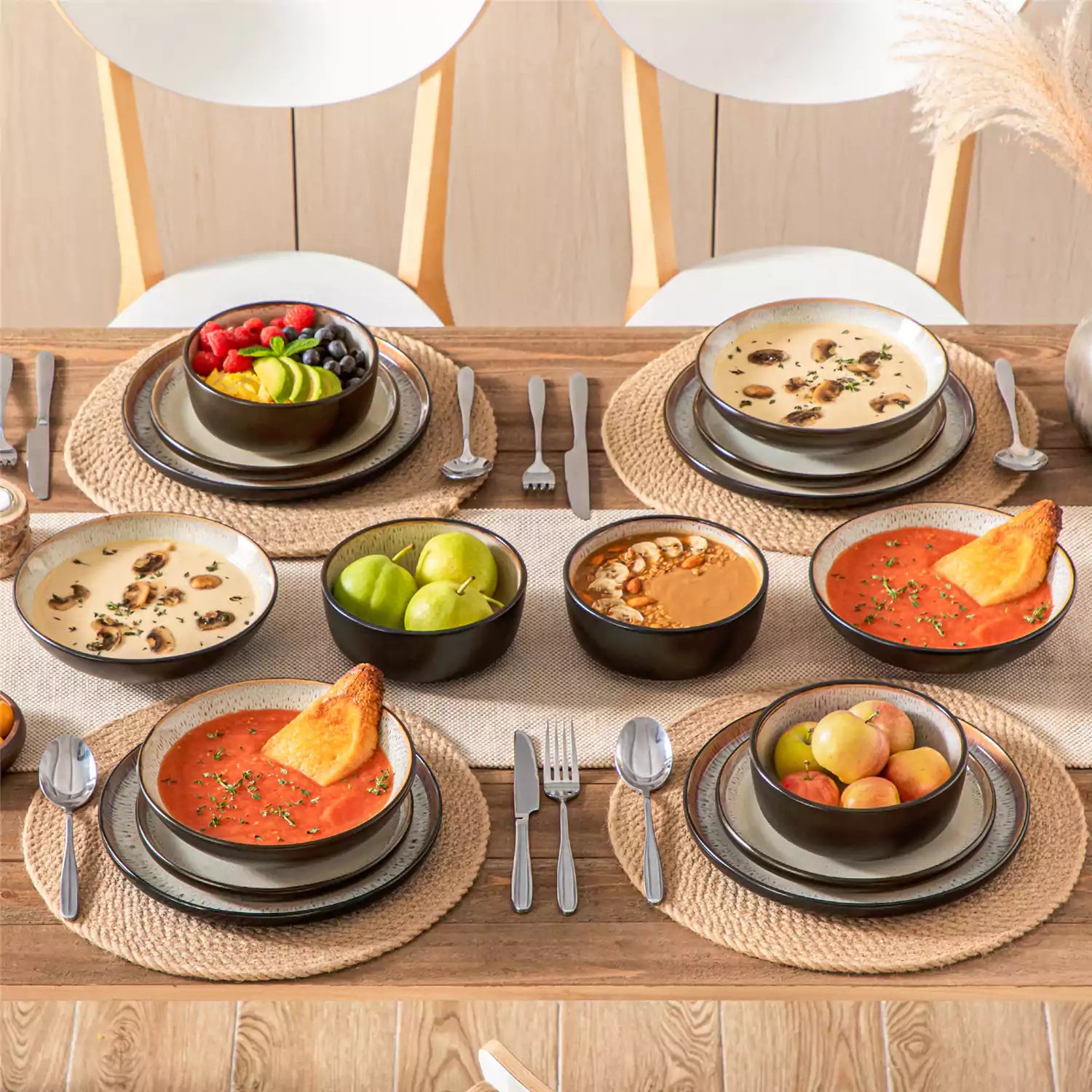 Assorted dishes with soup - dessert - and fruit salad on rustic wooden table - Amber 16-Piece beige stoneware dinnerware set with plates and bowls by vancasso
