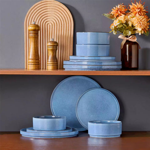 Anya 12 piece straight edge stoneware dinner set in blue with food on a rustic farmhouse wooden table with a side salad and cutlery