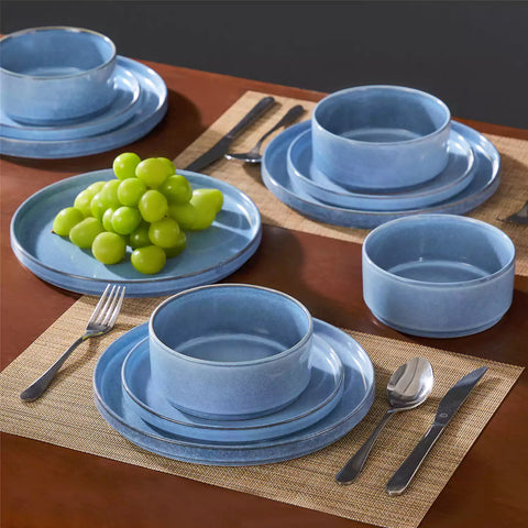 Anya 12 piece straight edge stoneware dinner set in blue with food on a rustic farmhouse wooden table with a side salad and cutlery