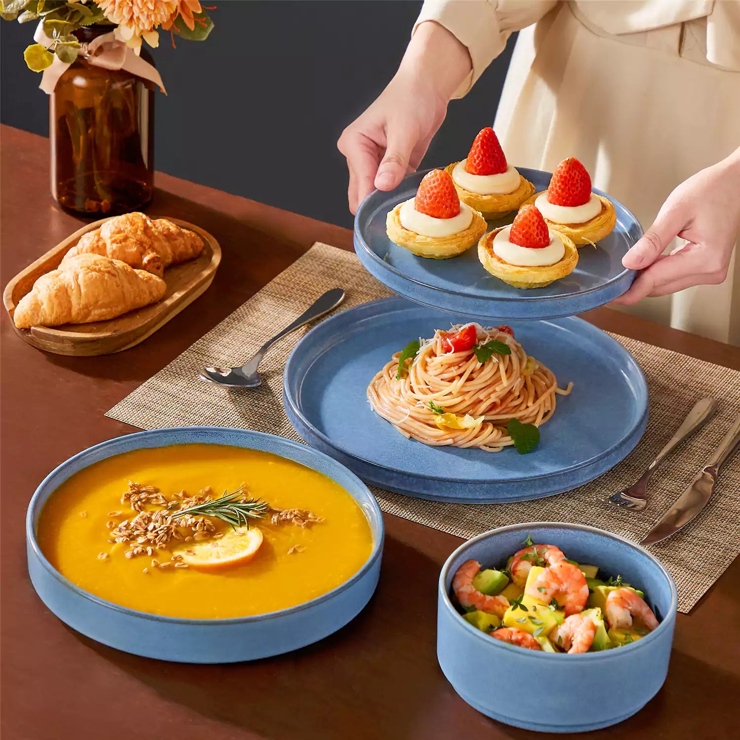 Anya 16 piece straight edge stoneware dinner set in blue with pasta soup and pastries on a modern farmhouse table