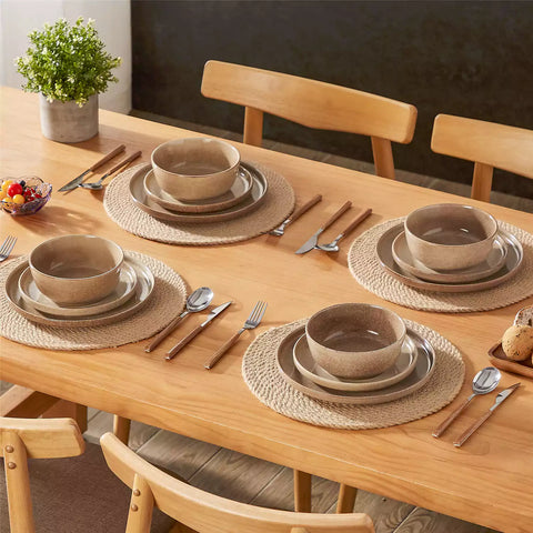 Caramel stoneware plates and bowls with reactive glaze on farmhouse wooden table with woven placemats