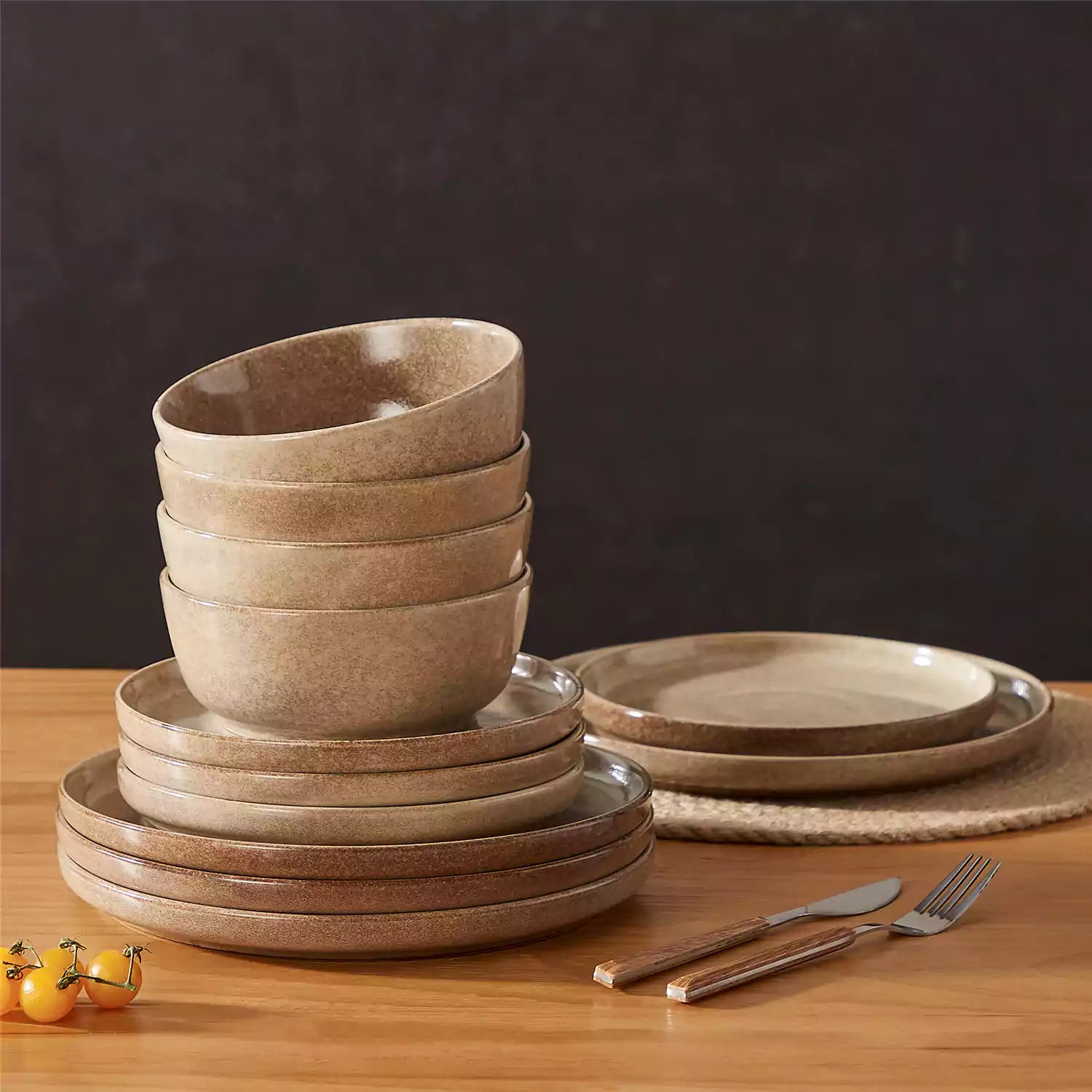 Caramel stoneware plates and bowls with reactive glaze on farmhouse wooden table with woven placemats