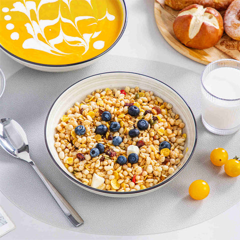 Bonbon double-sided stoneware pasta bowls in beige - artfully filled with pasta - fresh fruit salad - pumpkin soup - and oatmeal - exuding rustic charm on a white dining table
