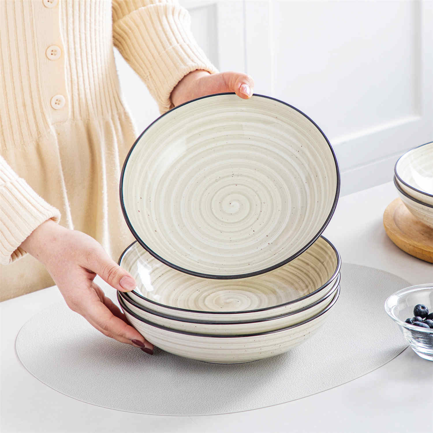 Bonbon double-sided stoneware pasta bowls in beige - artfully filled with pasta - fresh fruit salad - pumpkin soup - and oatmeal - exuding rustic charm on a white dining table