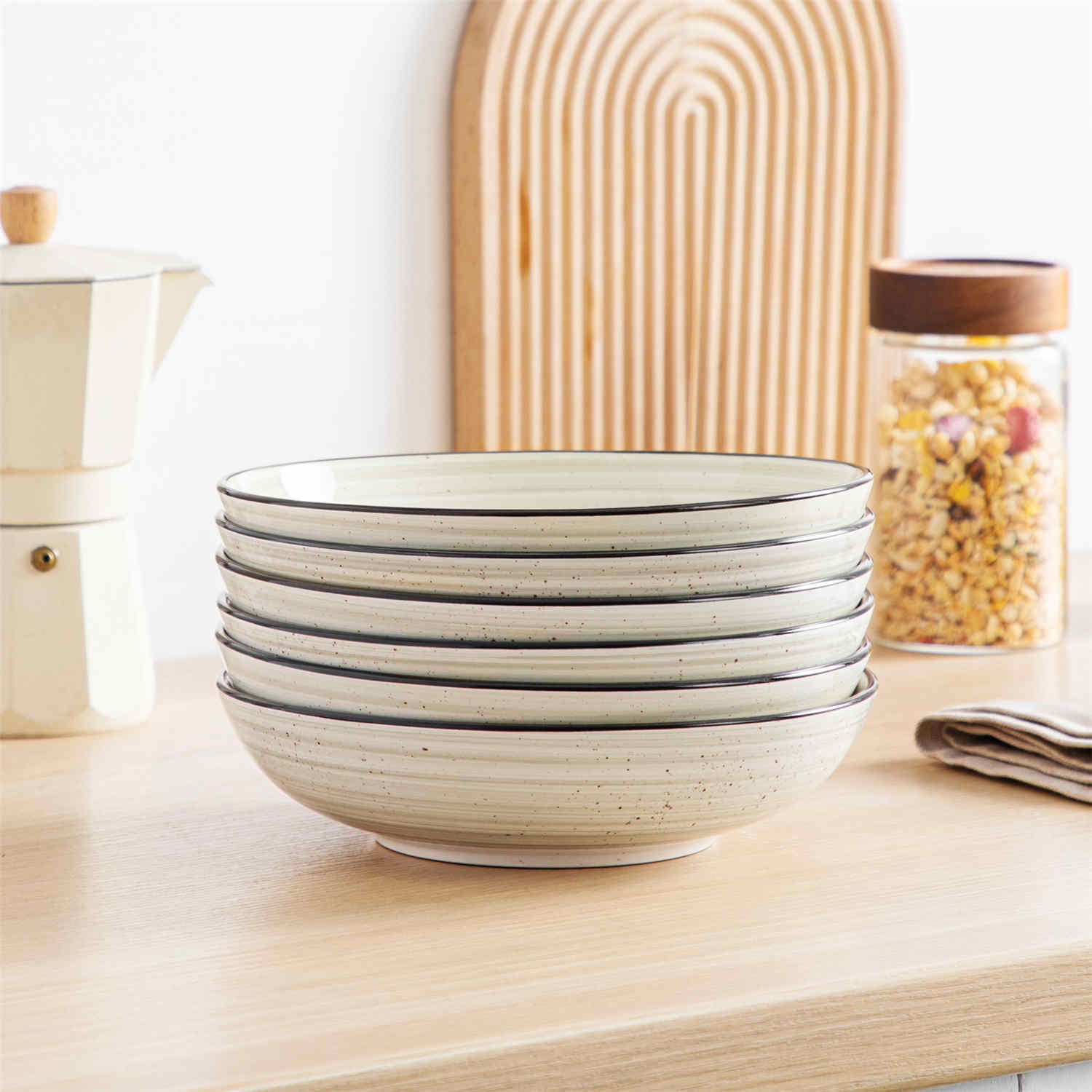 Bonbon double-sided stoneware pasta bowls in beige - artfully filled with pasta - fresh fruit salad - pumpkin soup - and oatmeal - exuding rustic charm on a white dining table