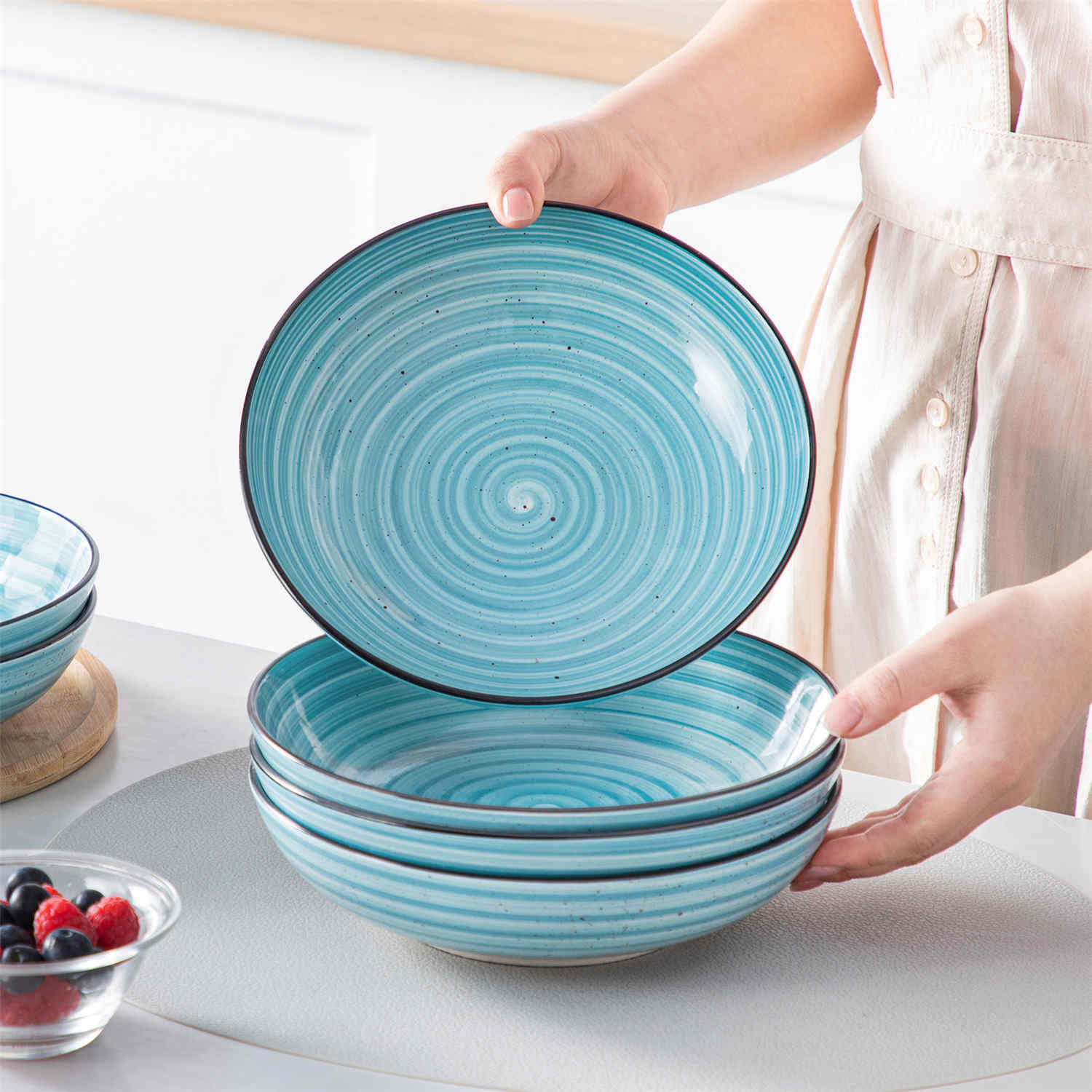 Bonbon double-sided stoneware pasta bowls in blue - artfully filled with pasta - fresh fruit salad - pumpkin soup - and oatmeal - exuding rustic charm on a white dining table