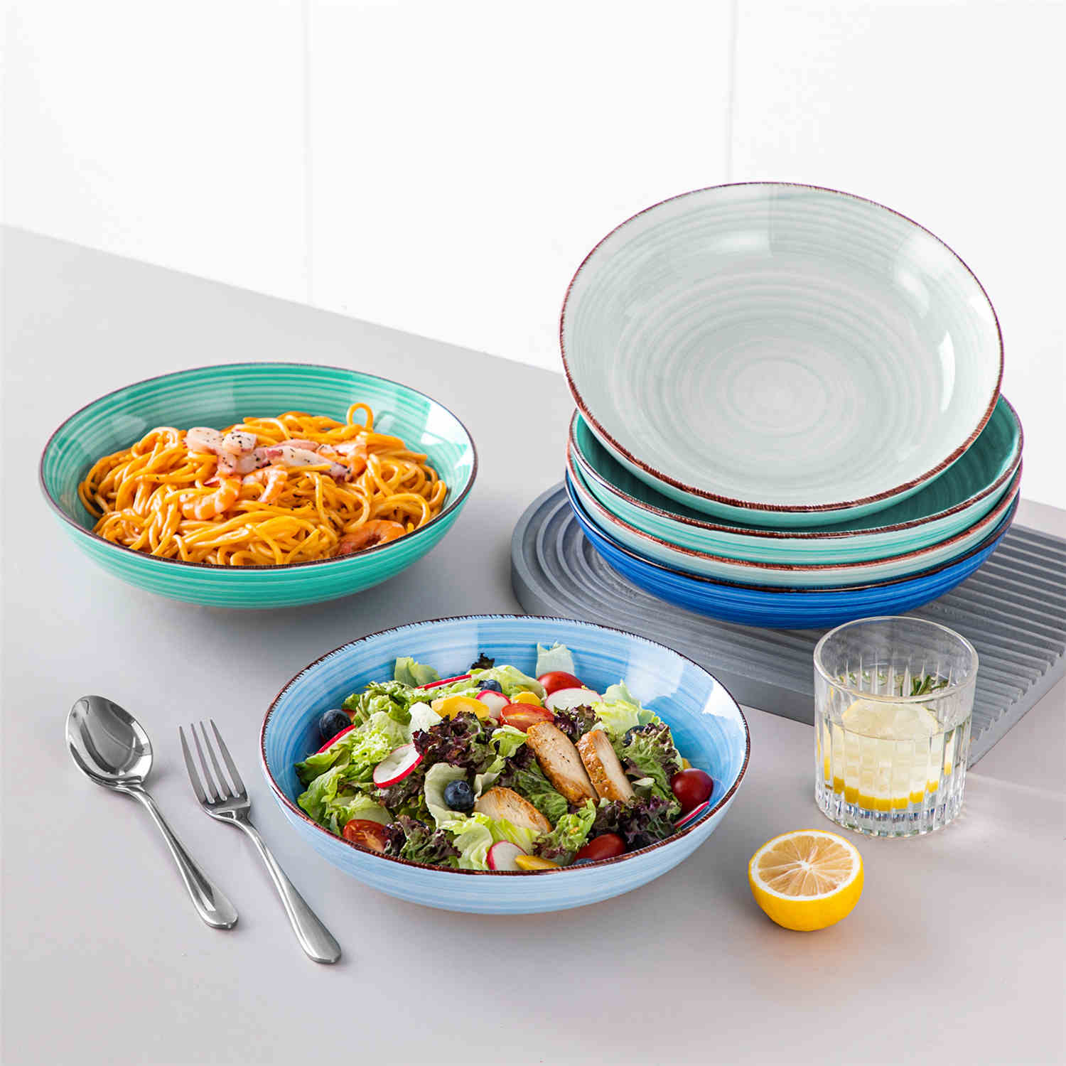 Blue Bonita large stoneware bowls set of 6 on a white table - each filled with pasta - pumpkin soup - and fruit salad - creating a bright and inviting table setting