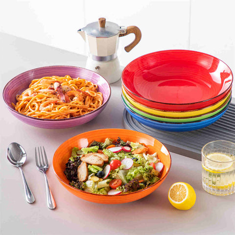 Multicolor Bonita large stoneware bowls set of 6 on a white table - each filled with pasta - pumpkin soup - and fruit salad - creating a bright and inviting table setting