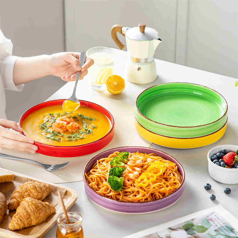 Bonita straight-edge pasta bowls set of 4 on a white table - filled with spaghetti - fruit salad - and mango - accompanied by a small honey jar - ibrant stoneware in rainbow blues