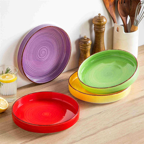 Bonita straight-edge pasta bowls set of 4 on a white table - filled with spaghetti - fruit salad - and mango - accompanied by a small honey jar - ibrant stoneware in rainbow blues