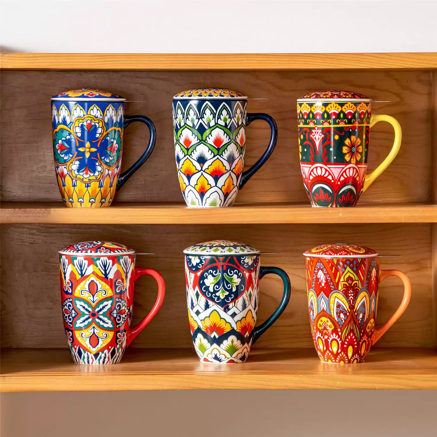 Lumi vibrant blue porcelain tea mug with infuser and lid featuring vibrant Bohemian pattern on a wooden desk with laptop and plant