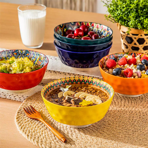 Colorful 26oz Lumi porcelain bowls on rattan placemats filled with oatmeal berries roasted broccoli and cherries on a linen table runner