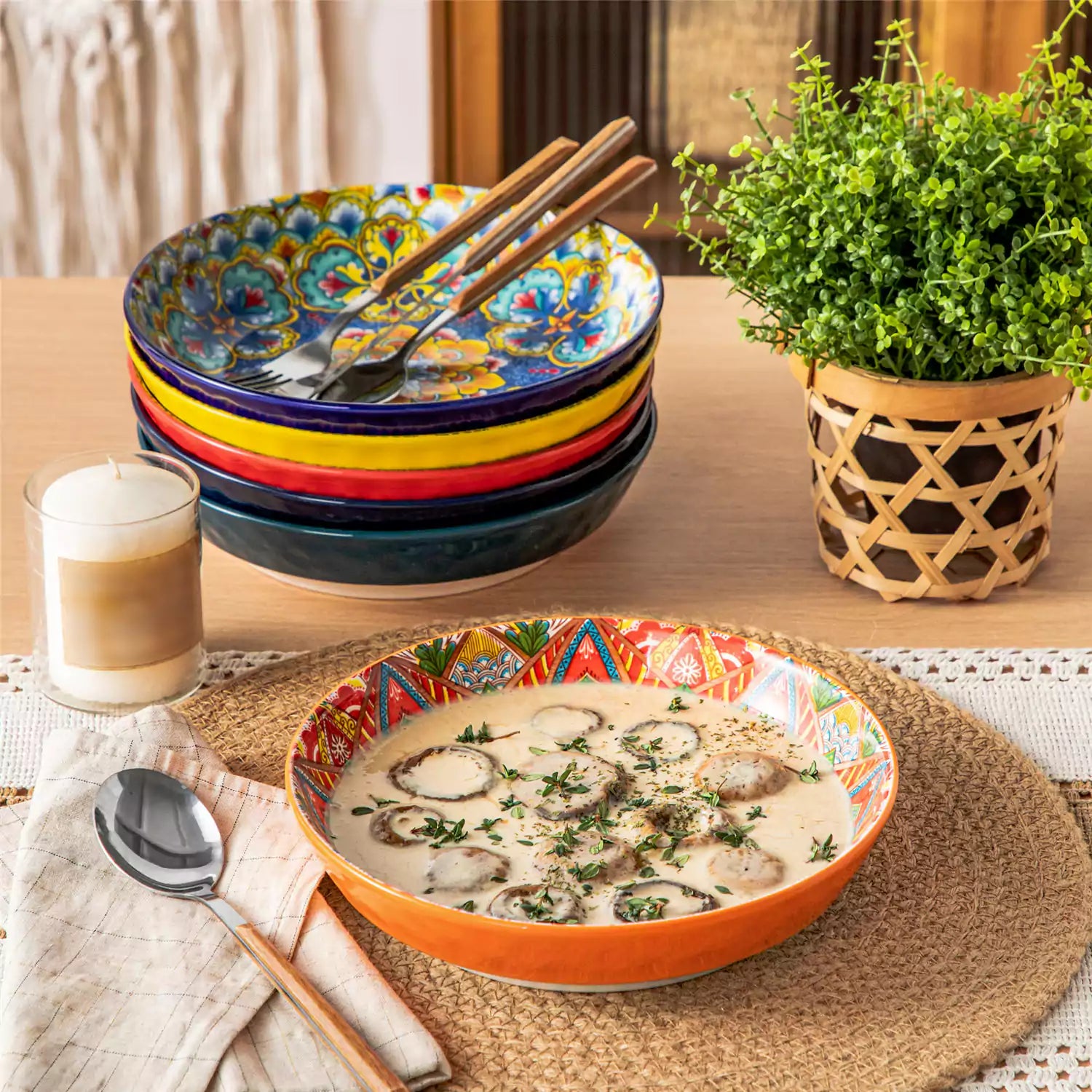 Vibrant Boho pasta bowls on a wooden table filled with pasta cherries and persimmons for a colorful, casual dining setting