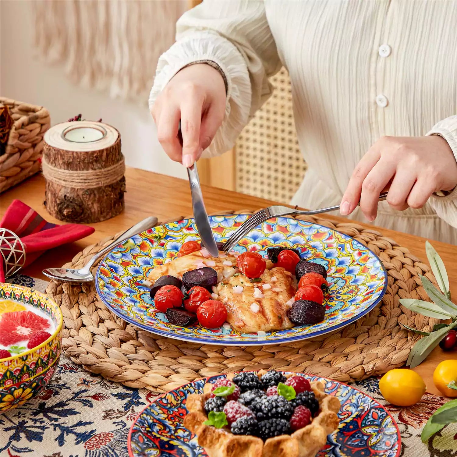 Lumi 12-piece Bohemian dinnerware set for 4 with colorful patterned plates and bowls on a wooden Boho dining table with food