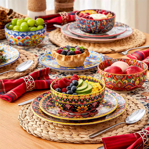 Lumi 12-piece Bohemian dinnerware set for 4 with colorful patterned plates and bowls on a wooden Boho dining table with food