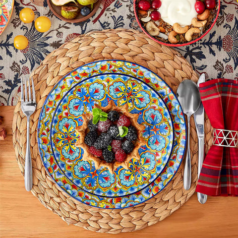 Lumi 12-piece Bohemian dinnerware set for 4 with colorful patterned plates and bowls on a wooden Boho dining table with food