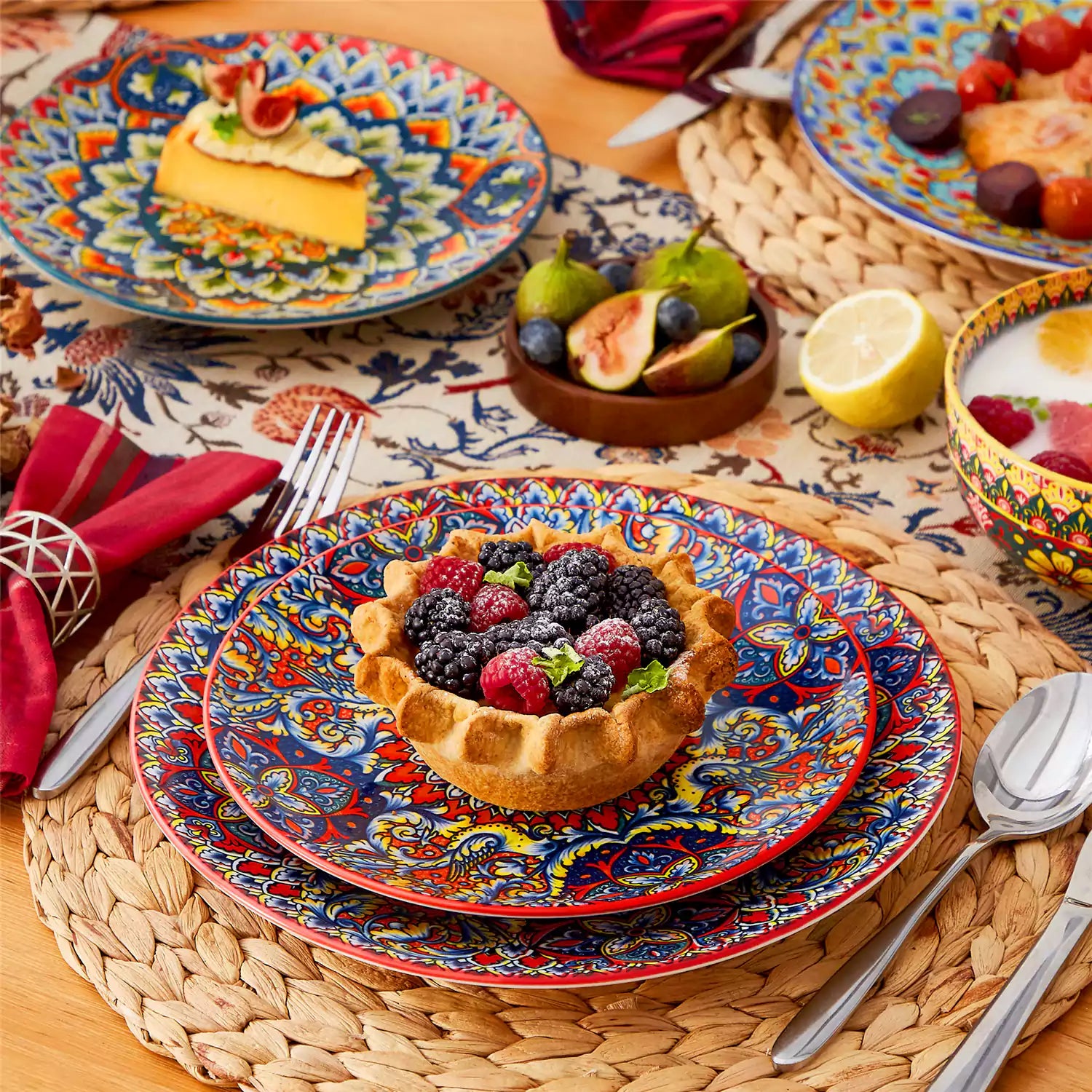 Lumi 18-piece Bohemian dinnerware set for six on a wooden table with colorful plates bowls and silverware in a playful Boho style