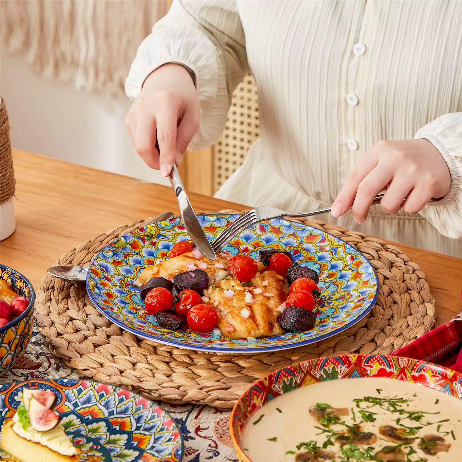 Bohemian style dining table set with Lumi 24 piece colorful dinnerware bowls and vibrant table décor ready for a lively meal