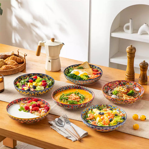 Vibrant Lumi porcelain pasta bowls filled with fruit salad pumpkin soup and pasta on a wooden dining table