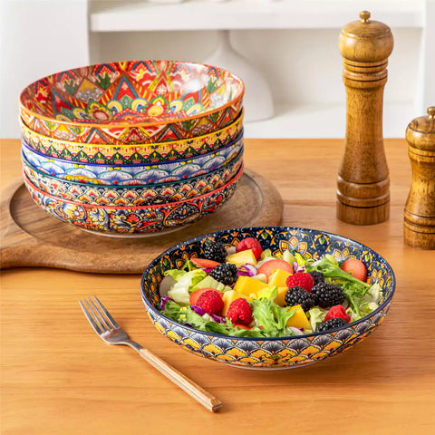 Vibrant Lumi porcelain pasta bowls filled with fruit salad pumpkin soup and pasta on a wooden dining table