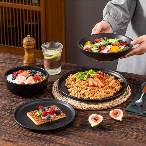 A matte black 24-piece stoneware dinnerware set from the Playa collection by vancasso - adding a modern flair with plates and bowls for 6 people
