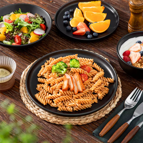 A matte black 24-piece stoneware dinnerware set from the Playa collection by vancasso - adding a modern flair with plates and bowls for 6 people