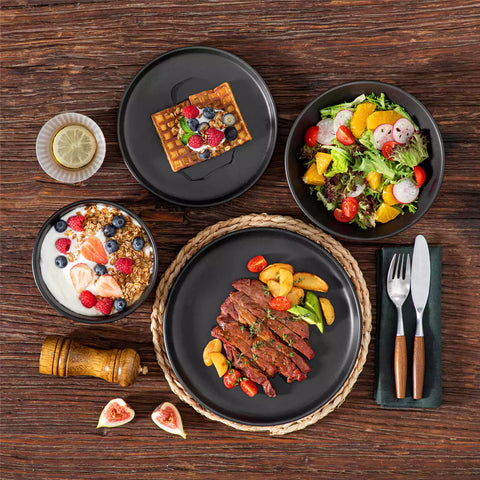 A matte black 24-piece stoneware dinnerware set from the Playa collection by vancasso - adding a modern flair with plates and bowls for 6 people