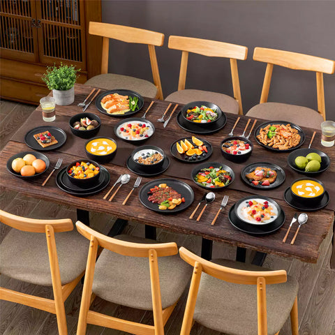 A matte black 24-piece stoneware dinnerware set from the Playa collection by vancasso - adding a modern flair with plates and bowls for 6 people