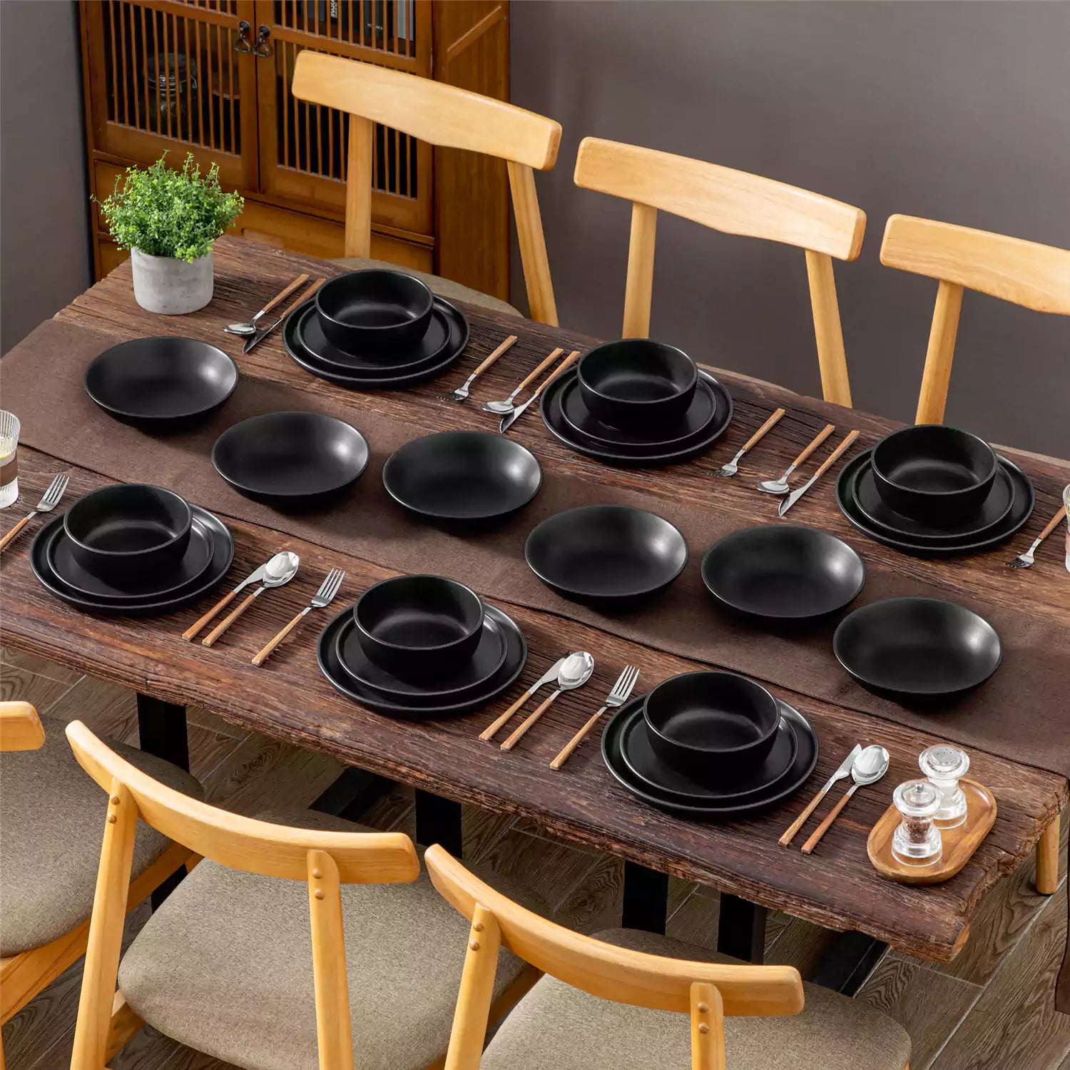 A matte black 24-piece stoneware dinnerware set from the Playa collection by vancasso - adding a modern flair with plates and bowls for 6 people