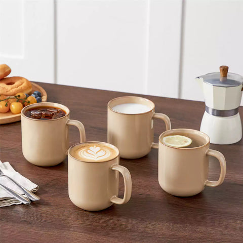 Playa 16oz stoneware mugs in brown reactive glaze on a rustic wooden café table with coffee maker and pastries