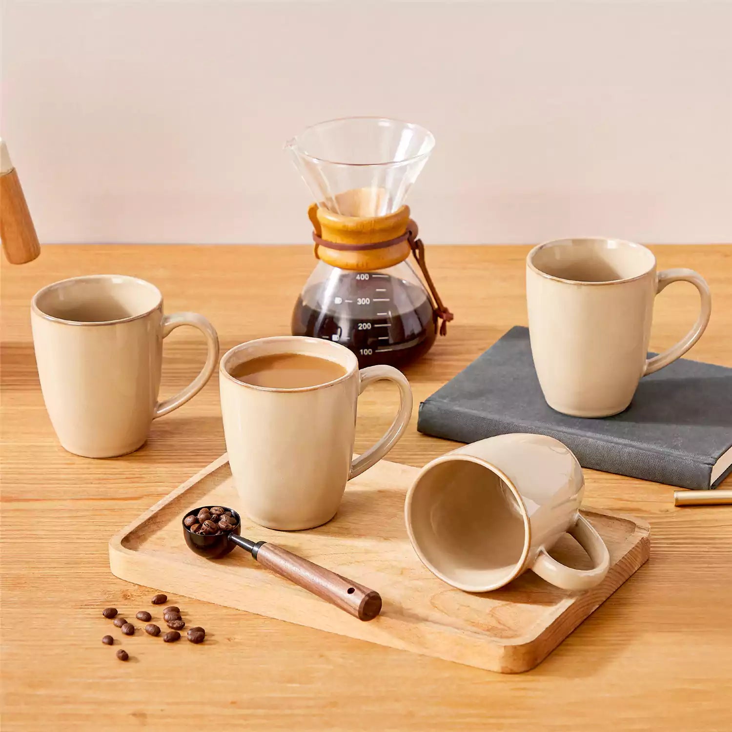 Playa set of four brown reactive glaze stoneware mugs on a wooden tray with a flat white and black coffee beside fresh croissants and berries