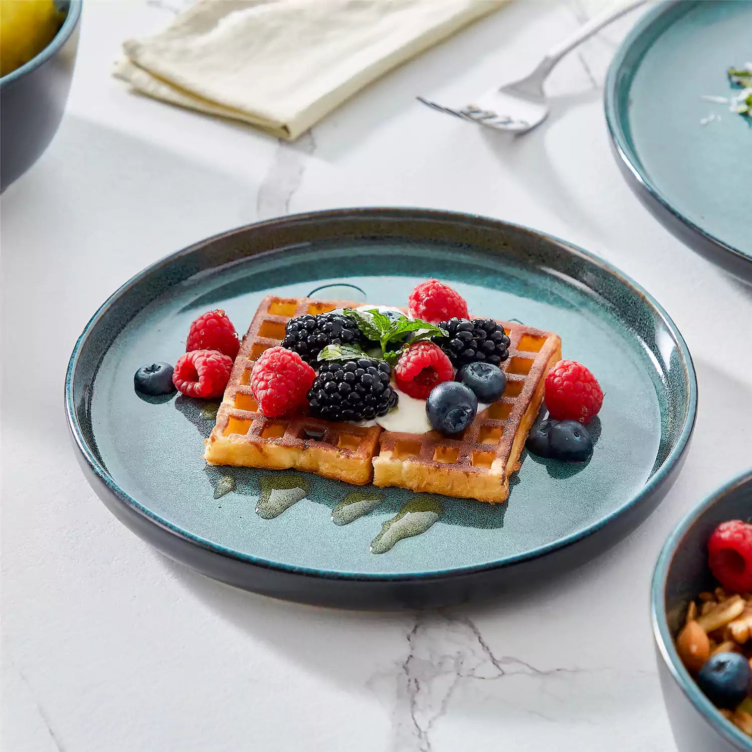 A glossy teal 24-piece stoneware dinnerware set from the Playa collection - featuring farmhouse charm with plates and bowls for 6 people-vancasso