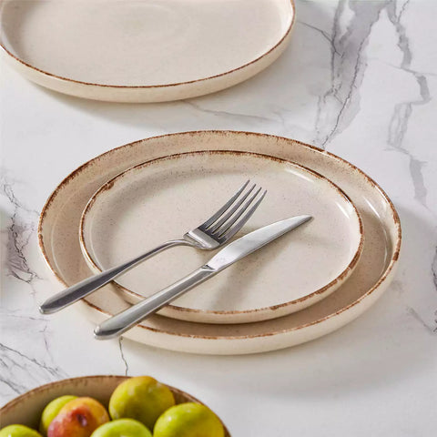 Plays 18-piece stoneware dinnerware set with steak and vegetables on marble table - featuring sandy speckled plates and bowls with brown rims-vancasso