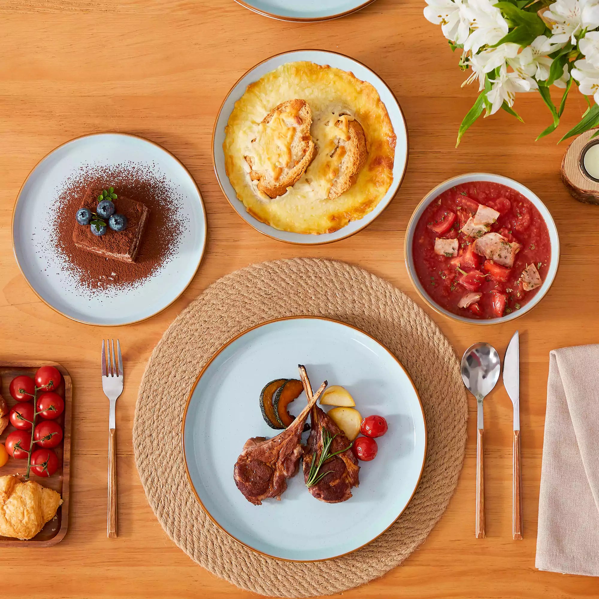 Rustic blue speckled stoneware dinnerware set with lipped-edge plates and bowls arranged on a sunlit modern dining table-vancasso