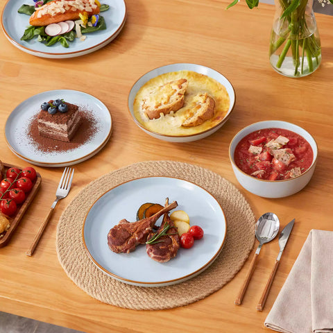 Rustic blue speckled stoneware dinnerware set with lipped-edge plates and bowls arranged on a sunlit modern dining table-vancasso