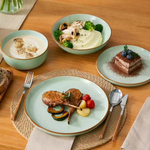 Rustic green speckled stoneware dinnerware set with lipped-edge plates and bowls arranged on a sunlit modern dining table-vancasso