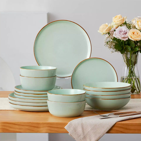 Rustic green speckled stoneware dinnerware set with lipped-edge plates and bowls arranged on a sunlit modern dining table-vancasso