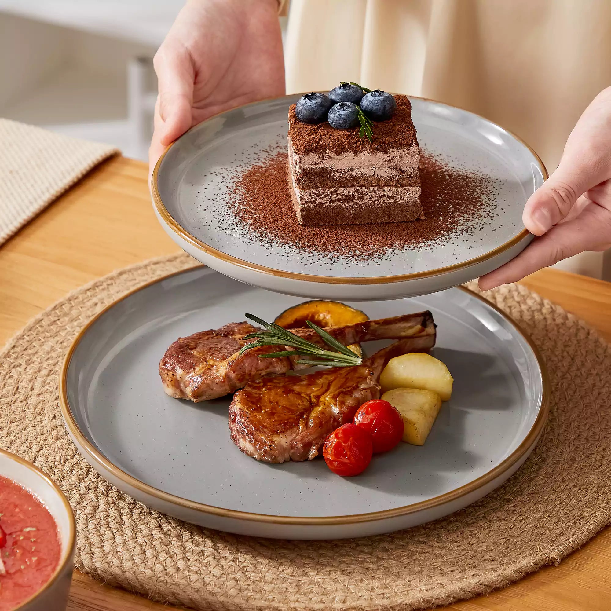 Grey rustic stoneware dinnerware set with speckled - lipped-edge plates and bowls on a dining table with flowers and cutlery in a cozy modern kitchen-vancasso
