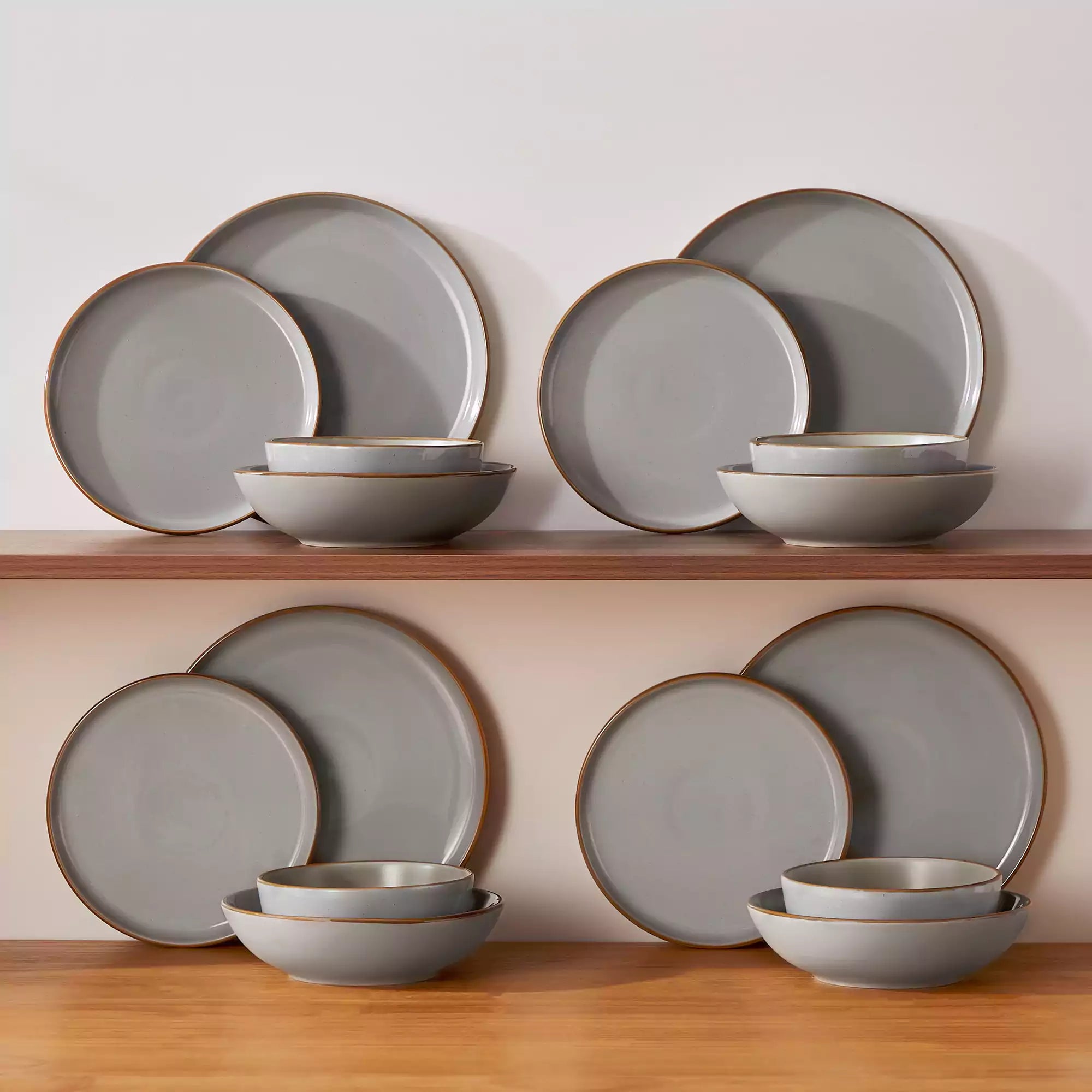 Rustic grey speckled stoneware dinnerware set with lipped-edge plates and bowls arranged on a sunlit modern dining table-vancasso