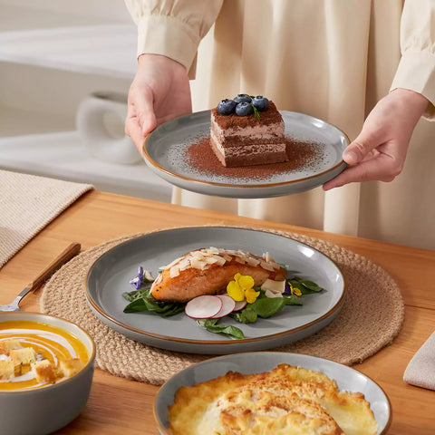 Rustic grey speckled stoneware dinnerware set with lipped-edge plates and bowls arranged on a sunlit modern dining table-vancasso